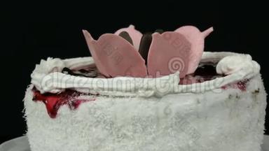 美丽时尚的甜鲜白蛋糕，樱桃果酱装饰在顶部，奶油和椰子薯片旋转。